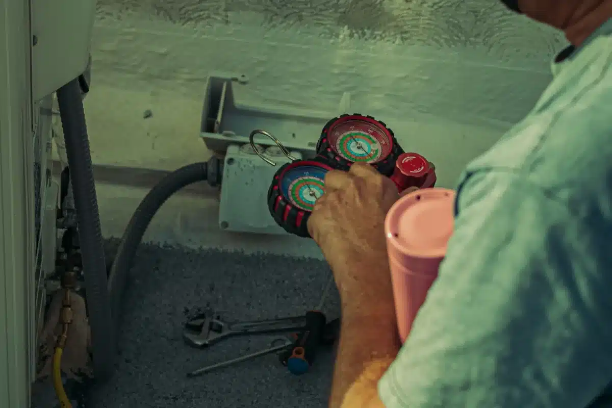 טכנאי מזגנים מחזיק מדי לחץ לבדיקת מערכת הגז